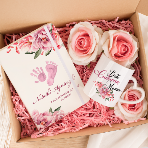 Zestaw prezentowy dla przyszłej mamy. Pudełko z notatnikiem i kubkiem w różowej kolorystyce.