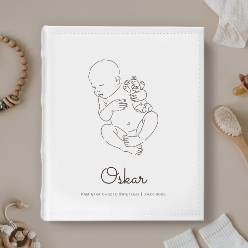 Album na wklejane zdjęcia ma personalizowaną okładkę z grafiką chłopca. Prezent na Chrzest.