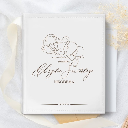 Album na zdjęcia z białą okładką, na której widoczna jest grafika dziecka i dedykacja na Pamiątkę Chrztu Świętego