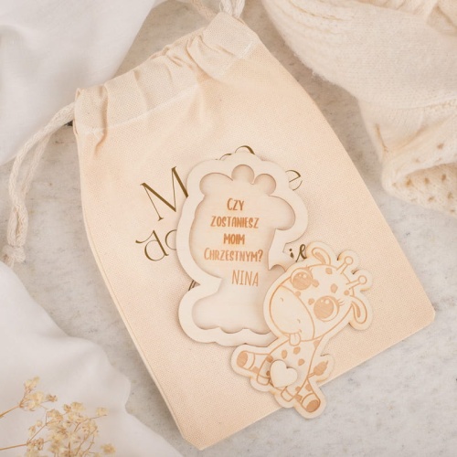 Drewniana tabliczka w kształcie żyrafy z ukrytym pytaniem o bycie rodzicem chrzestnym.