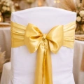 Szarfa satynowa złota do dekoracji krzesła.