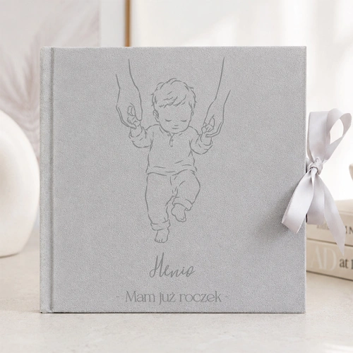 Personalizowany album welurowy na zdjęcia dla chłopca na roczek ma okładkę z imieniem i dziecięcą ilustracją.