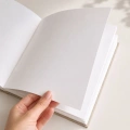 Grube białe kartki w welurowym albumie księdze na zdjęcia i pamiątkowe wpisy.