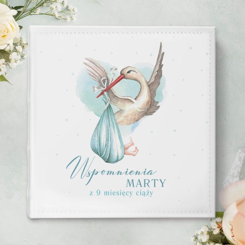 Album na zdjęcia z kolekcji Bociankowe Błękitne. Piękny prezent na Baby Shower udekorowany jest grafiką bociana i niebieską kolorystyką.