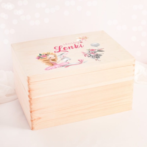 Personalizowana skrzynia na zabawki w postaci drewnianego pojemnika. Na wieczku znajduje się miejsce na imię dziewczynki.