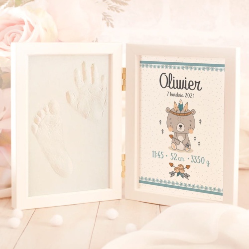 Otwierane pudełeczko z metryczką dziecka i miejscem na odcisk dłoni i stopy. po lewej stronie. Po prawej stronie grafika z szarym misiem w indiańskim pióropuszu.