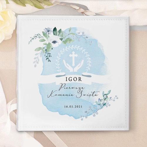 Kwadratowy album na zdjęcia komunijne. Na sztywnej okładce ze sztucznej skóry widoczna błękitna akwarela, kwiatowe kompozycje i personalizacja przez Was wybrana.