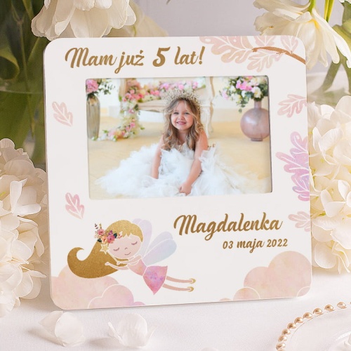 Ramka na fotografię w białym kolorze. Wzbogacona jest o grafikę przedstawiającą wróżkę, magiczny świat. Świetny prezent na urodzinki dziewczynki.