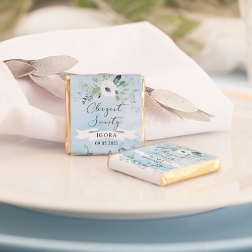 Czekoladka personalizowana na Chrzciny dla zaproszonych osób. Wzbogacona o ozdobną etykietkę w błękitnym odcieniu.